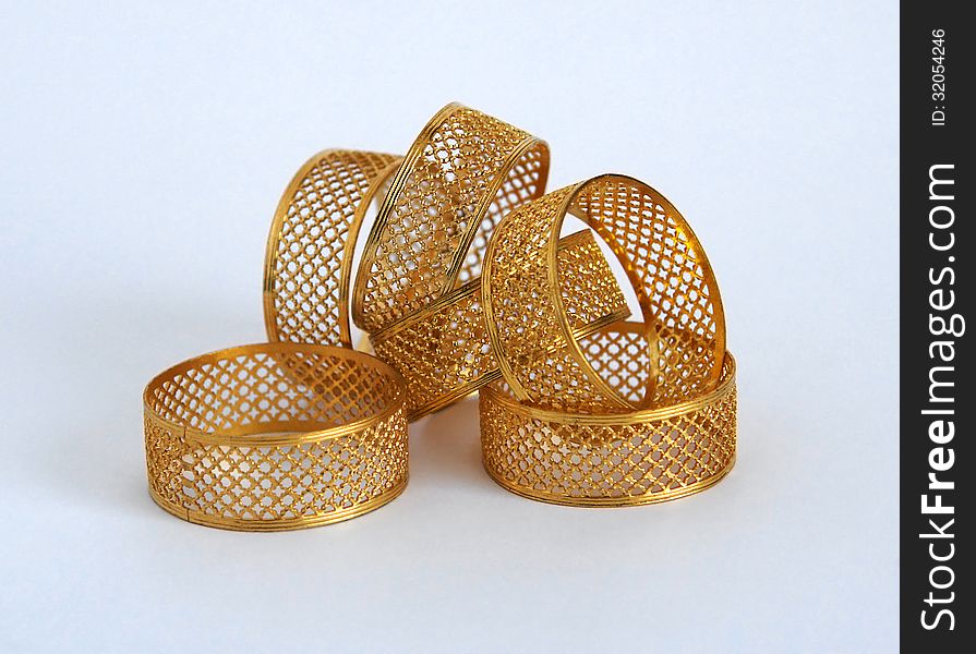 Golden napkin holders in the form of openwork rings. Golden napkin holders in the form of openwork rings