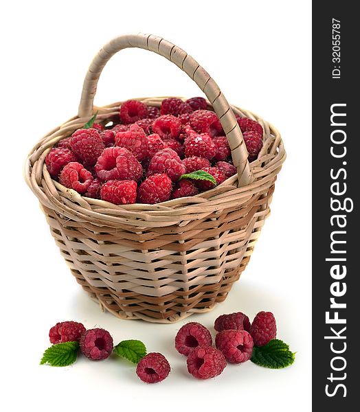 Fresh sweet raspberries in a wicker basket on white.