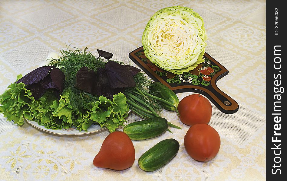 Lettuce, dill, onions on a white plate and vegetables ( tomatoes, cucumbers, cabbage). Lettuce, dill, onions on a white plate and vegetables ( tomatoes, cucumbers, cabbage).