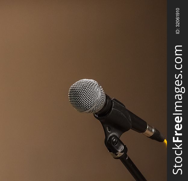 Classic black microphone on black stand. brown background. Classic black microphone on black stand. brown background