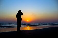 Man Silhouetted Against A Vivid Ocean Sunset Royalty Free Stock Photo