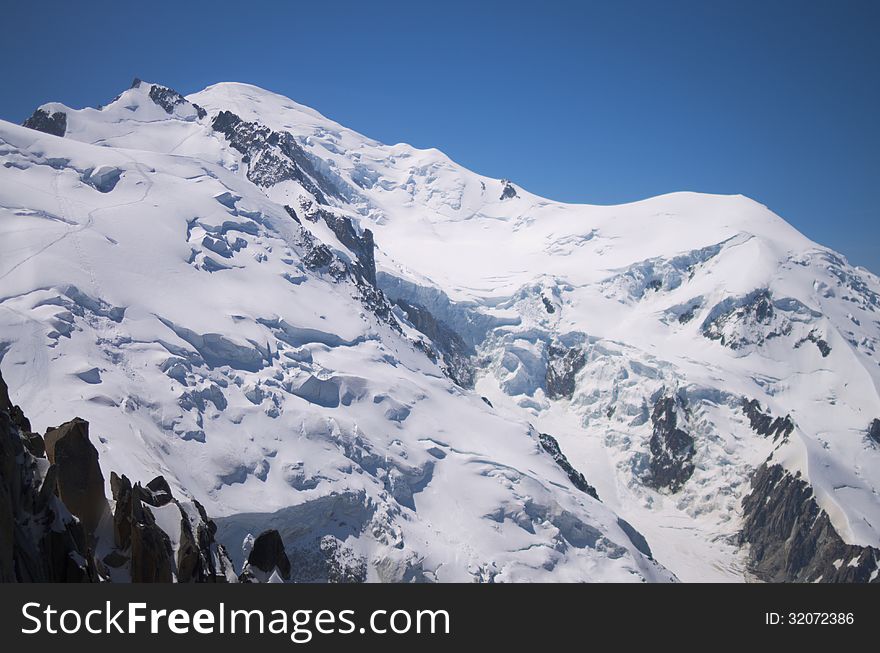 Snow peak of Mont-Blanc mountain, close, with traces of mountaineers. Chamonix, France. Taken in July 2013.