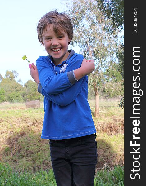 Six-year-old-girl posing and laughing while walking and collecting wild flowers in Australian parkland. Six-year-old-girl posing and laughing while walking and collecting wild flowers in Australian parkland