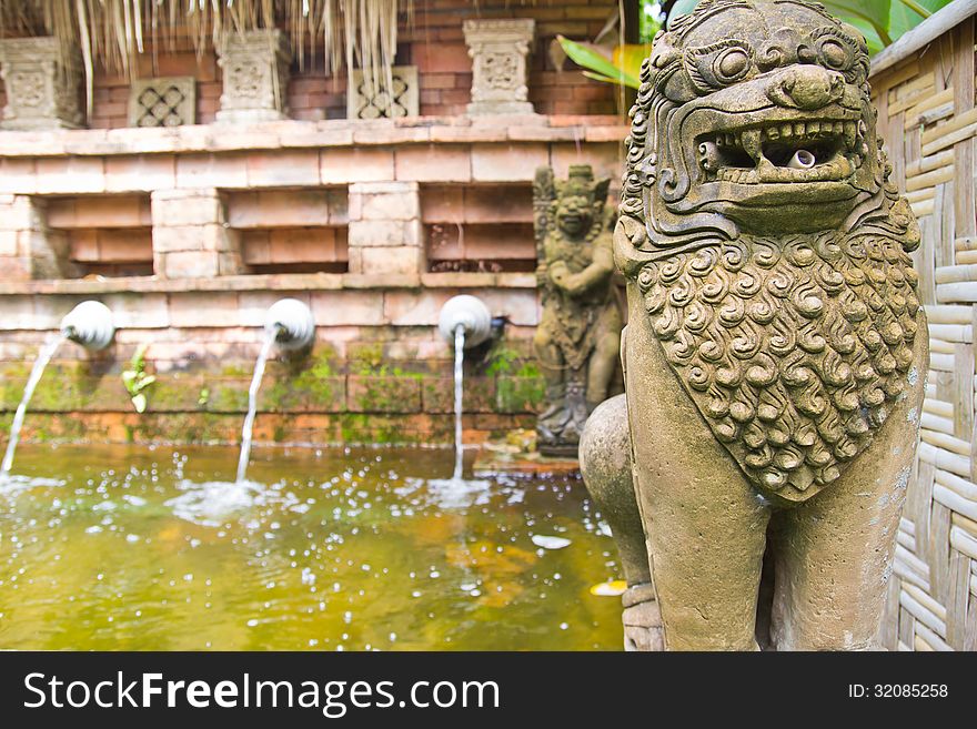 The lion statues made of stone. Stand in front of park.Garden design Thai style.