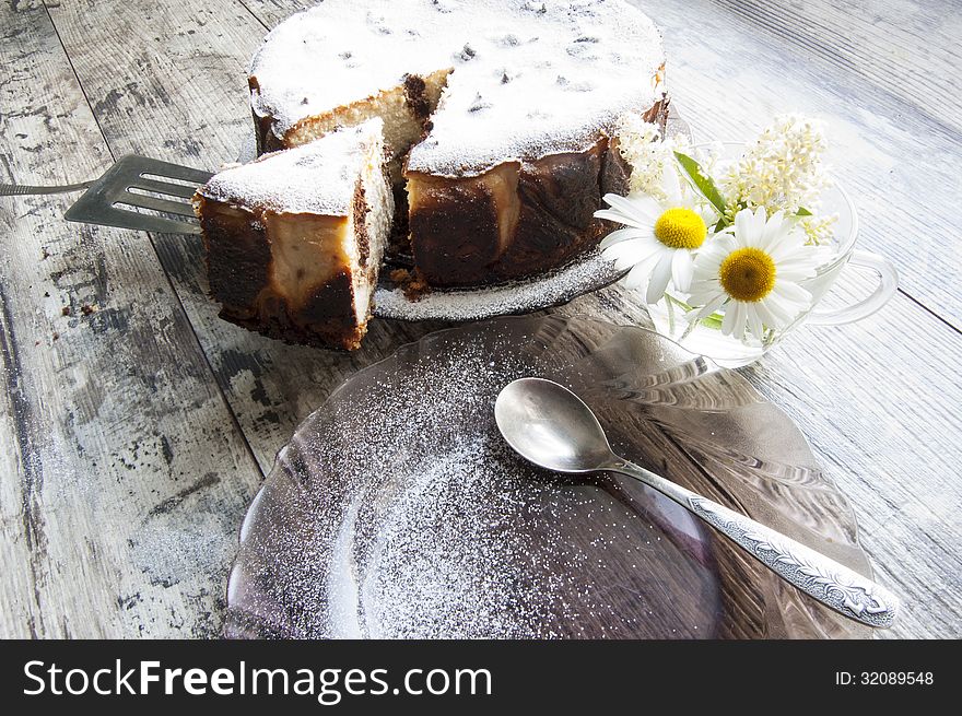 Cheesecake on a glass dish whith bouquet of chamom
