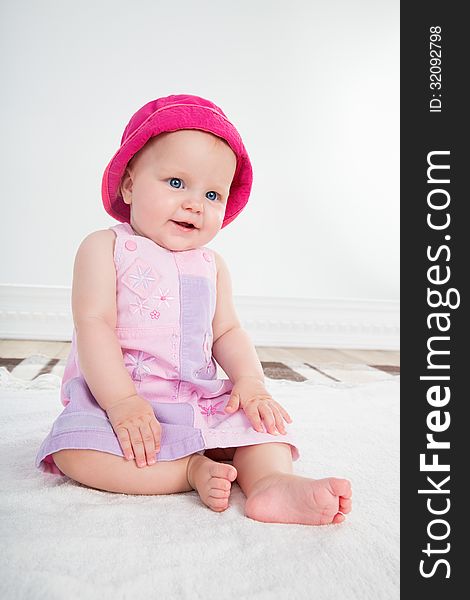 Pretty baby girl with big blue eyes sits in pink dress. Pretty baby girl with big blue eyes sits in pink dress