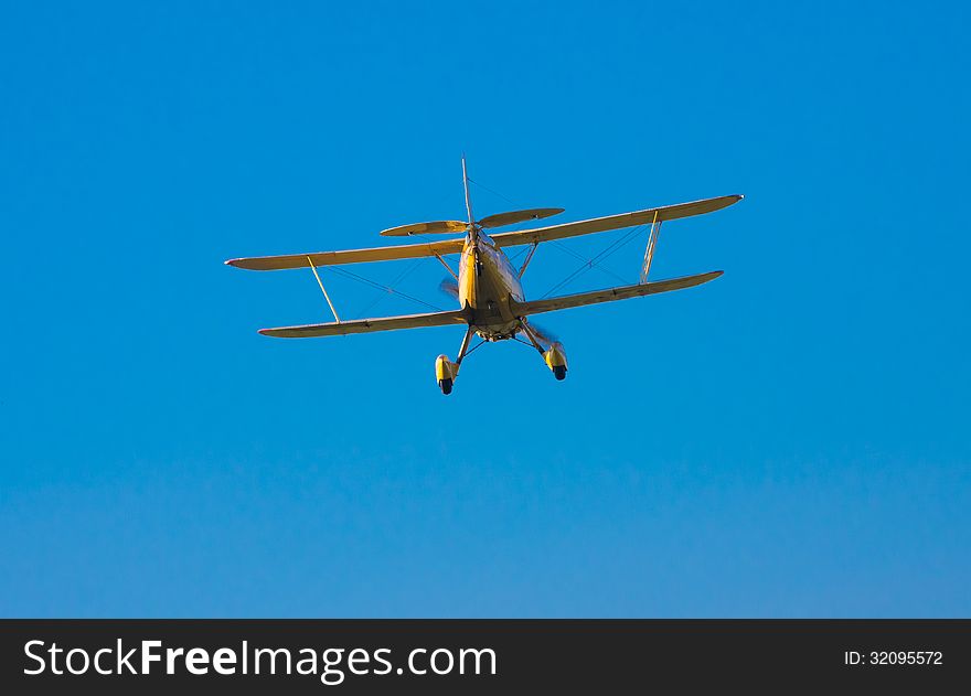 An old but well kept, yellow biplane coming in for a landing. An old but well kept, yellow biplane coming in for a landing.