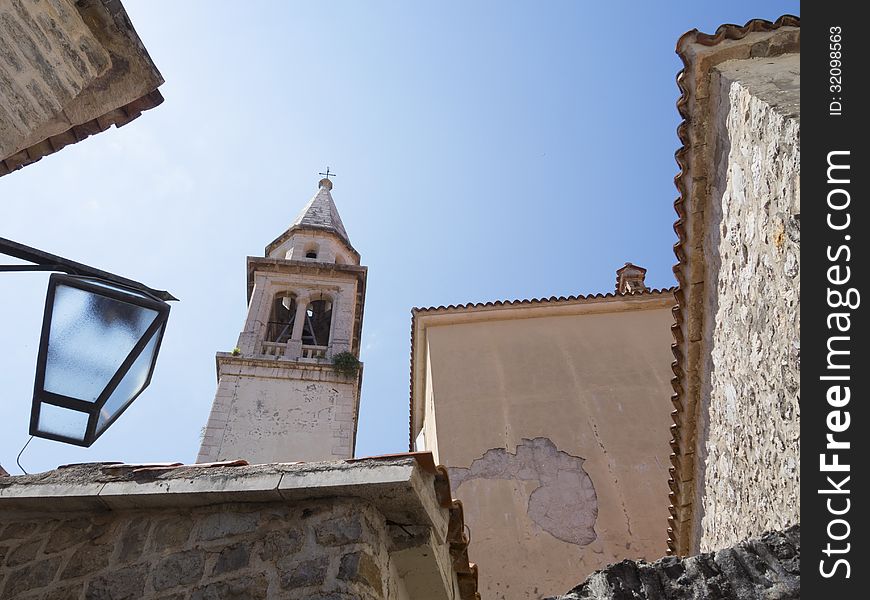 Bell tower of St.John cathedral in tight urban space of Old City in Budva Montenegro. Bell tower of St.John cathedral in tight urban space of Old City in Budva Montenegro