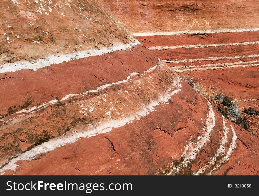 Red and white layers of sandstone curve and recede in close-up view. Red and white layers of sandstone curve and recede in close-up view