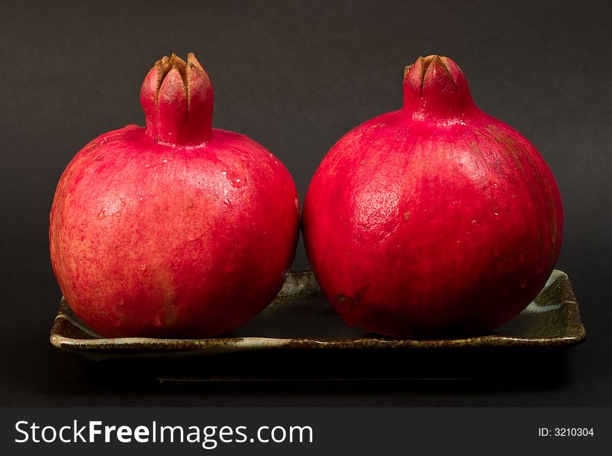 Two pomegranates on ceramic plate
