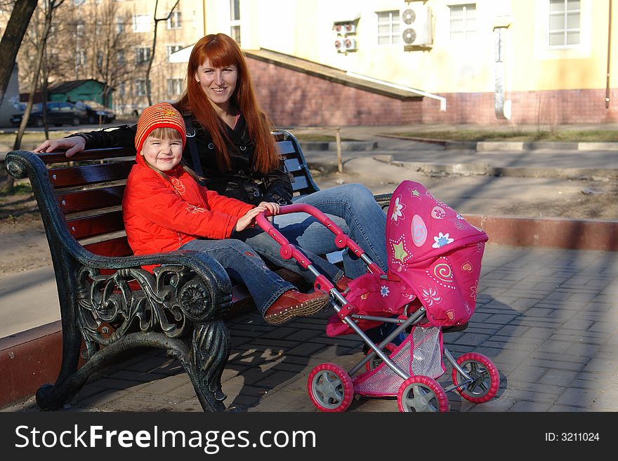 Mum and small daughter with a carriage. Mum and small daughter with a carriage