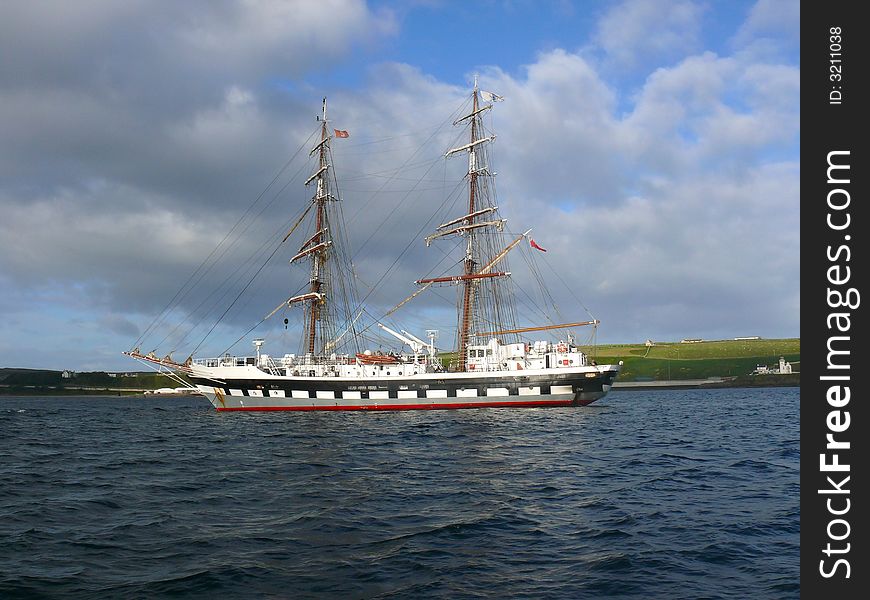 A two masted schooner type sailing training ship at anchor in a calm blue sea. A two masted schooner type sailing training ship at anchor in a calm blue sea.