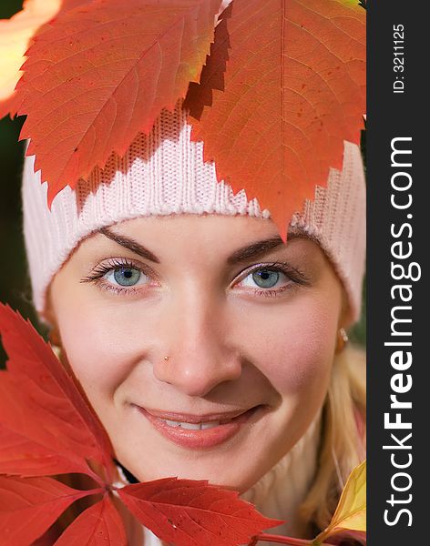 Close-up portrait of a girl with autumn leaves