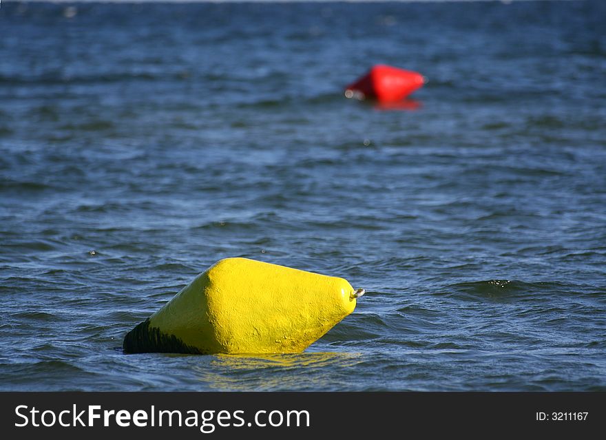 Yellow buoy on a foreground with red one blurred in background. Yellow buoy on a foreground with red one blurred in background