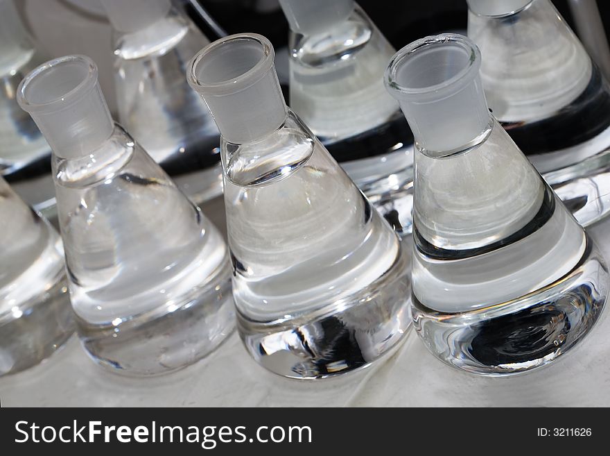 Erlenmeyer flasks with colorless liquid in chemistry lab. Erlenmeyer flasks with colorless liquid in chemistry lab