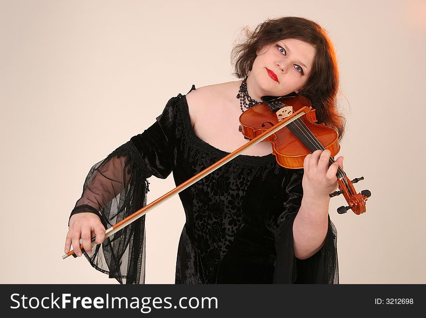 Girl playing with her fiddle and is looking foreword. Girl playing with her fiddle and is looking foreword