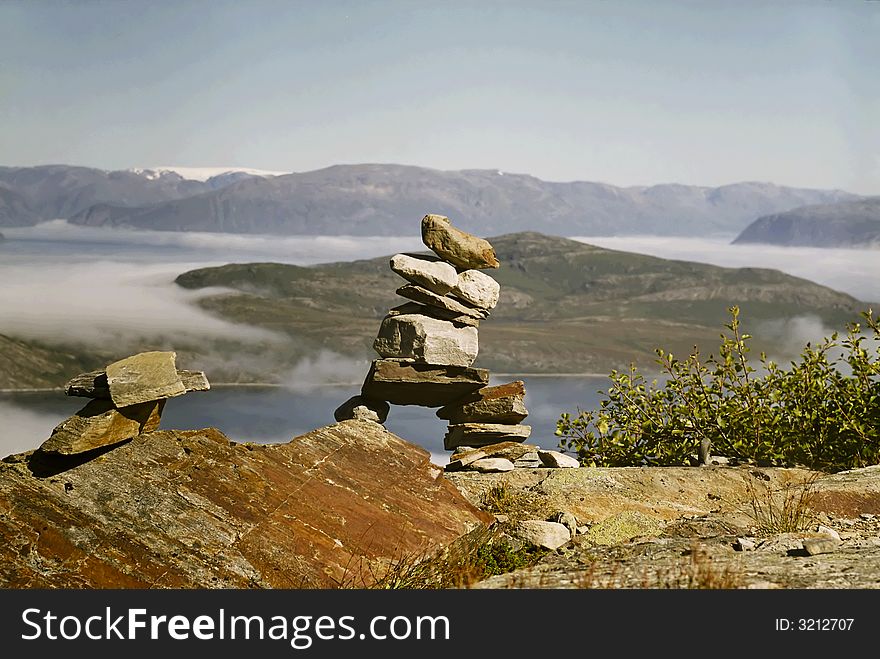 Small building made of stones. In background sea and clouds. View in norway