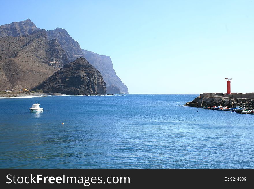 Port of Saint Nicholas in Canary Islands with the rocky outcrops of the south of the island. Port of Saint Nicholas in Canary Islands with the rocky outcrops of the south of the island