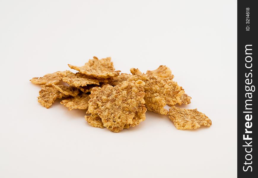 A pile of wheat flakes on white