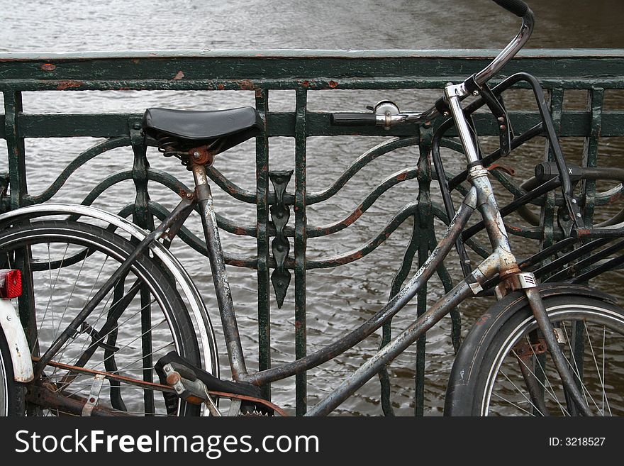 An old rusty bike along the canal in Amsterdam, Holland