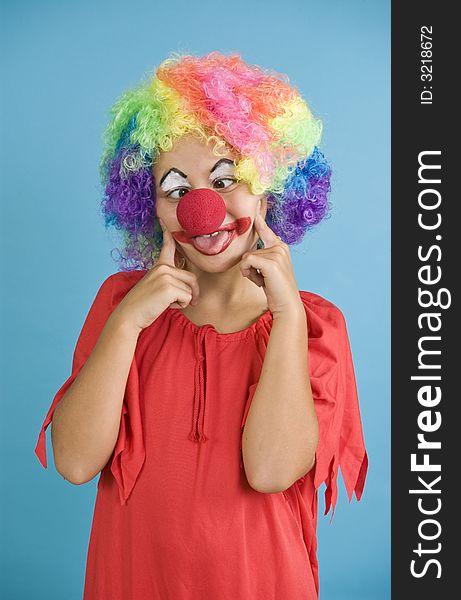 A child dressed in a clown costume playing the part. A child dressed in a clown costume playing the part.