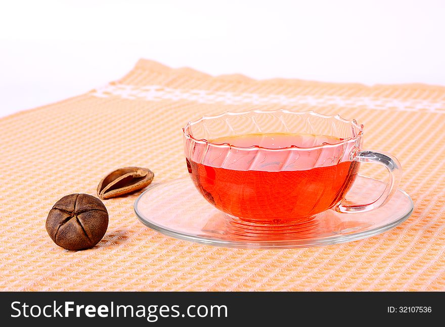 Tea in a glass cup, a glass saucer and decoration. Tea in a glass cup, a glass saucer and decoration