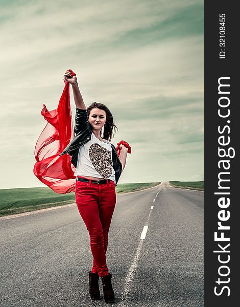 Beautiful girl stay on road with fabric opening wide from wind