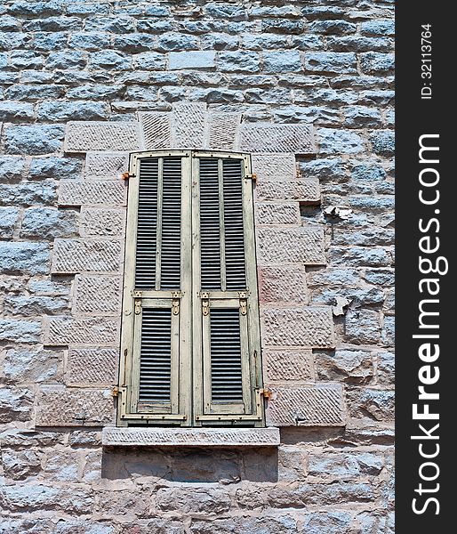 Typical old Mediterranean window with closed shutters