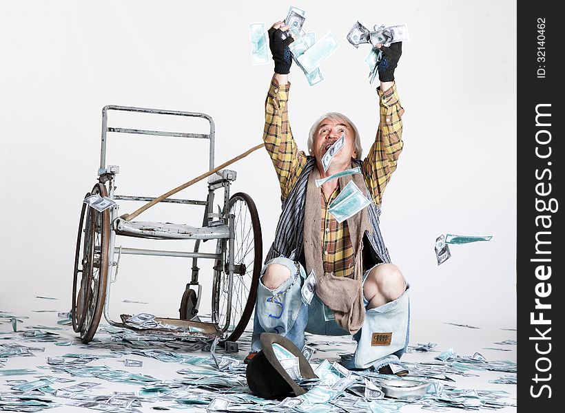 Homeless man with a wheelchair with a lot of money on a white background. Homeless man with a wheelchair with a lot of money on a white background