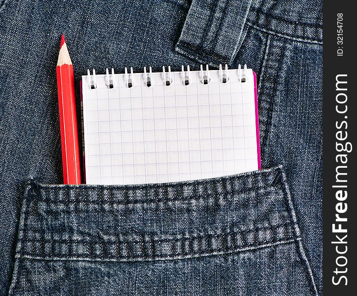 Notebook and red pencil in jeans pocket