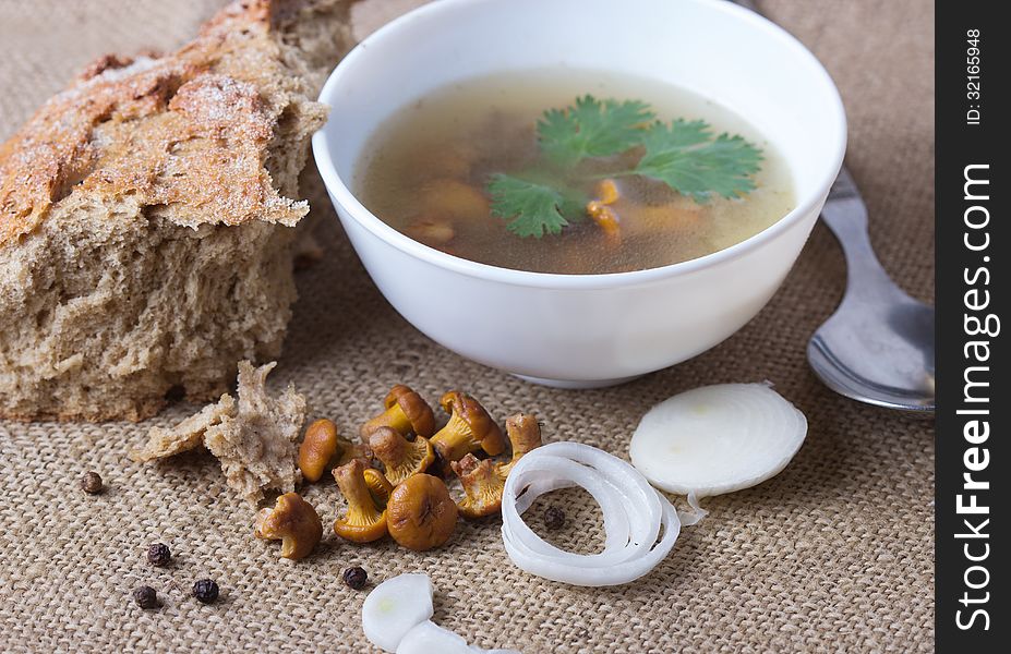 Cup of soup with chanterelles with onion and bread