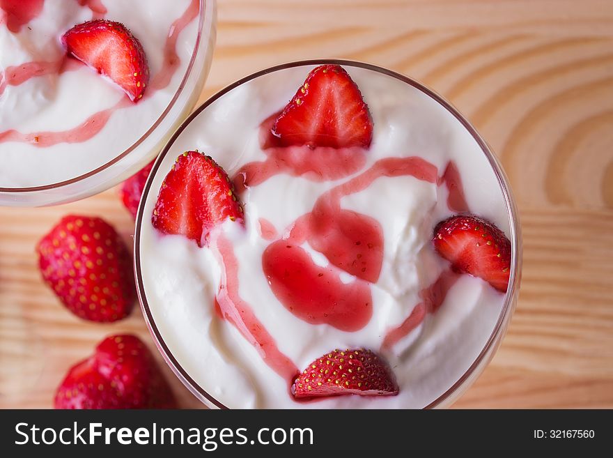 Strawberry yogurt with strawberries on a wooden background. Strawberry yogurt with strawberries on a wooden background