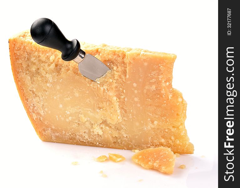 Parmesan cheese with knife on a white