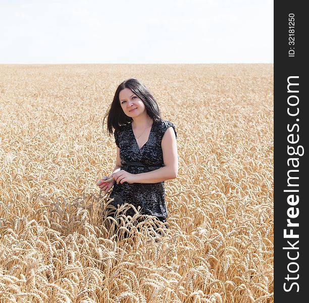 Girl on the field with wheat summer day