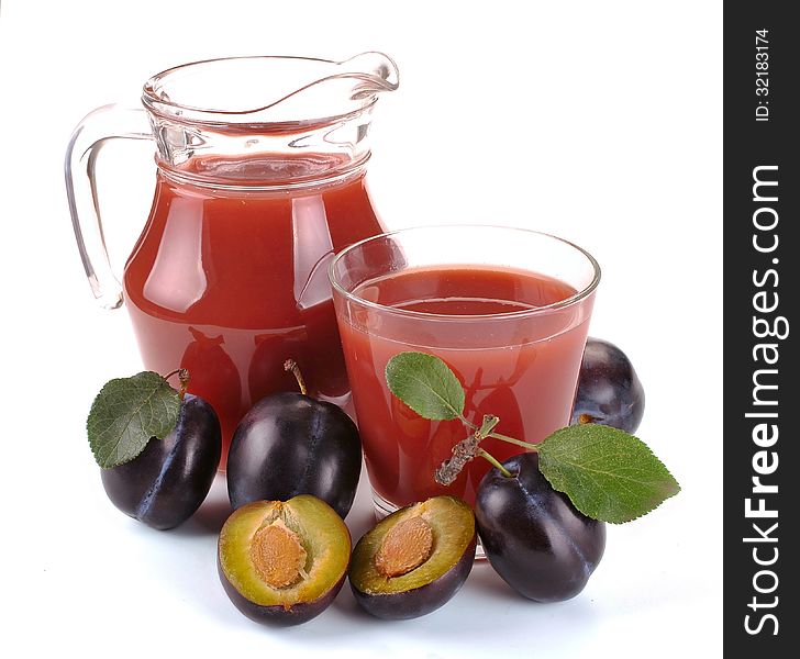 Plum juice in a jug and a glass of fruit. Plum juice in a jug and a glass of fruit