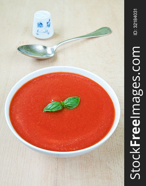 Fresh tomato soup with basil in a bowl