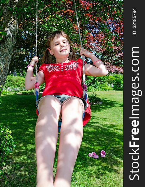 Cute child girl have fun on garden swing