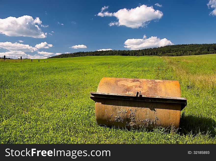 Agricultural machine on the field with trees in the background. Agricultural machine on the field with trees in the background