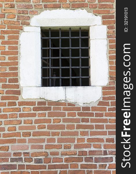 Old window with metal bars in the wall of church , Krakow,Poland.