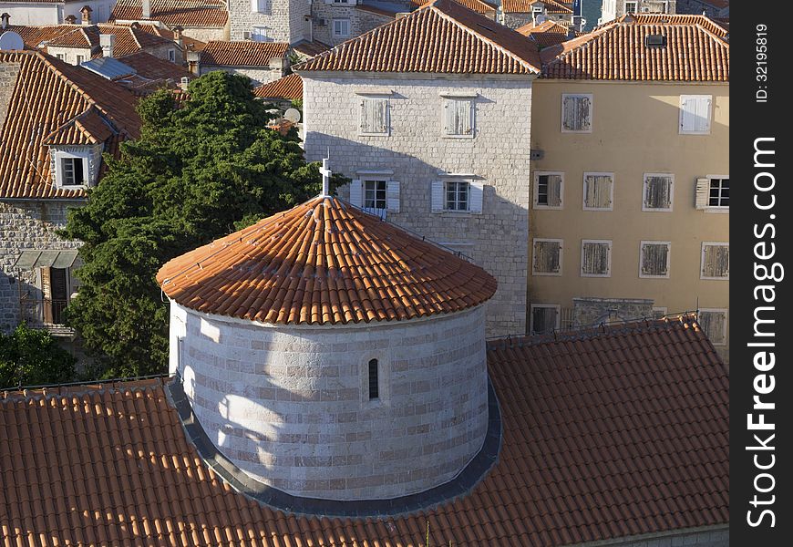 Top view to Budva old city with dome of St.John Cathedral on foreground