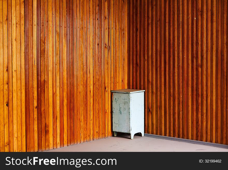 Bedside table in the corner on a panel natural wood background