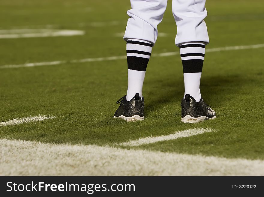 Referre's feet on a football field from behind. Referre's feet on a football field from behind.