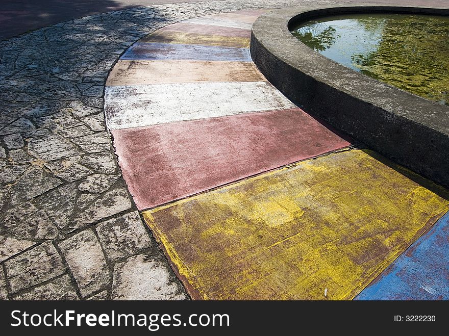 Tiles of different colour formed a beautiful picture with rugged tiles and a circular pond. Tiles of different colour formed a beautiful picture with rugged tiles and a circular pond