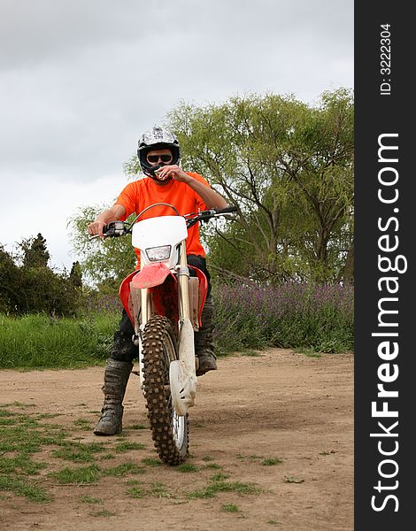 Young biker frontal view on a dirt track