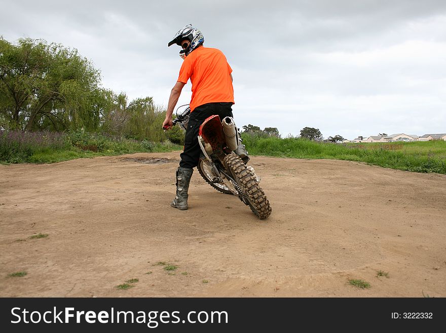 Biker looking back over his shoulder at a dirt track