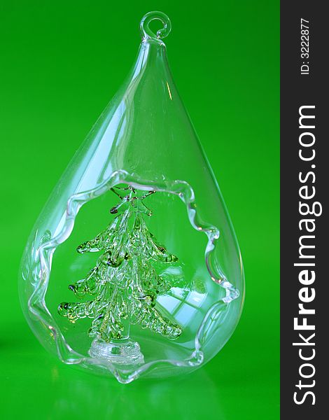 Glass Christmas Tree in a teardrop shape on a green background. Glass Christmas Tree in a teardrop shape on a green background