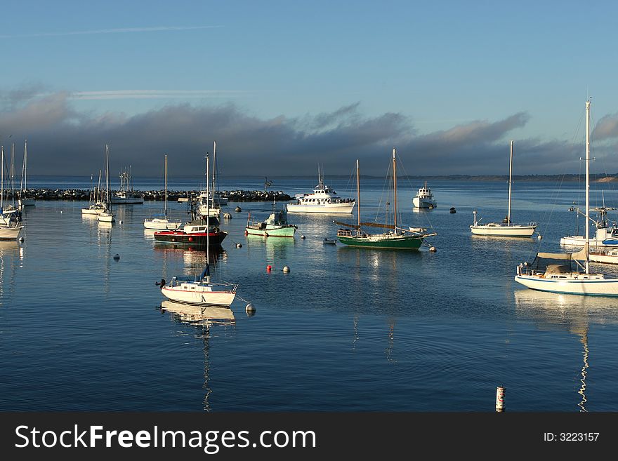 Boats Docked in Harbor at Sunset with clouds and blue sky. Boats Docked in Harbor at Sunset with clouds and blue sky