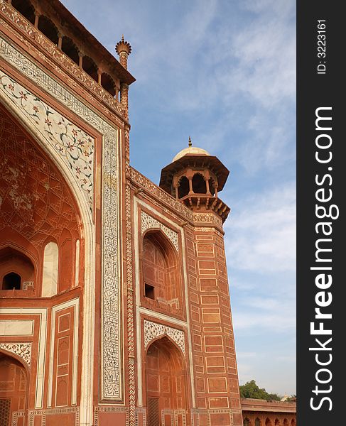 Fragment of red-brick decorated minaret in taj mahal mausoleum site with blue sky. Agra, India. Fragment of red-brick decorated minaret in taj mahal mausoleum site with blue sky. Agra, India