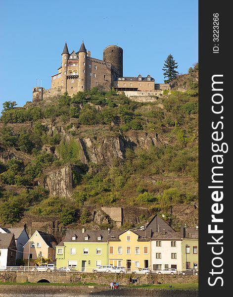 Medieval castle on hill and authentic small houses, vertical.