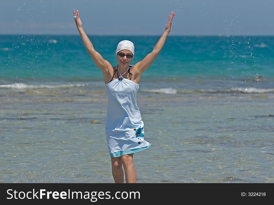 Woman being sprinkled at the seaside